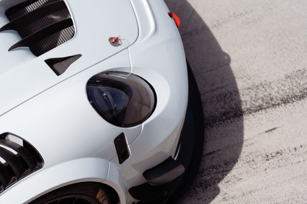 Detalhe frontal do farol de um Porsche 911 moderno.