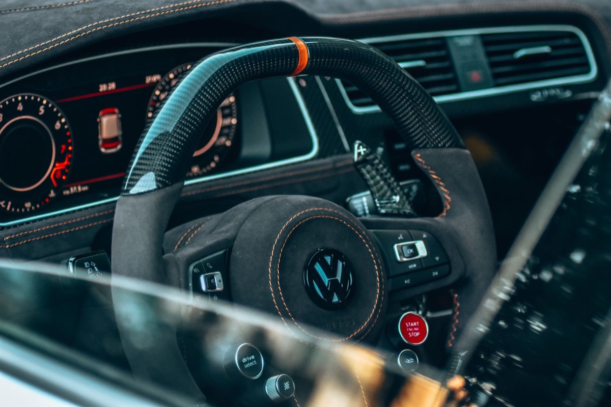 Close-up of a luxury electric vehicle cockpit with carbon fiber detailing and digital interface.