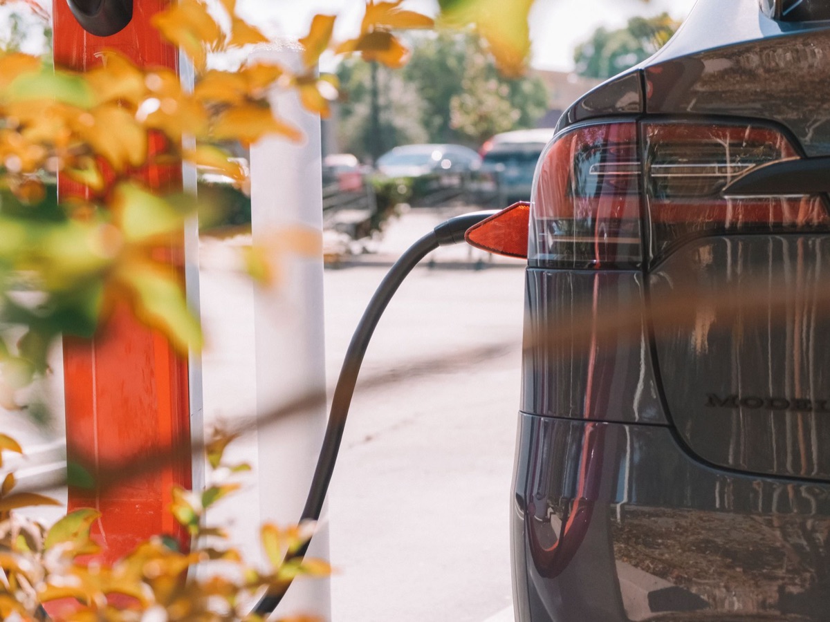 Silhueta de um carro esportivo elétrico de luxo com porta de carregamento visível.