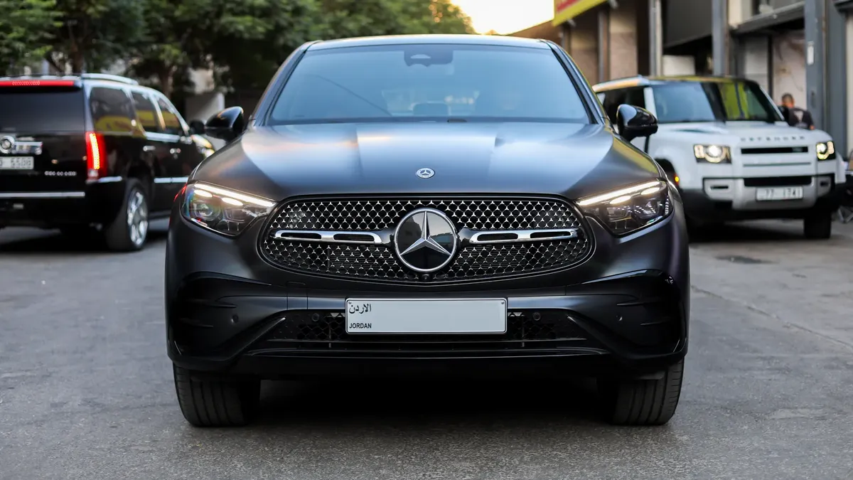 Front view of a sleek Mercedes-Benz SUV in a city setting, showcasing luxury in Amman, Jordan.