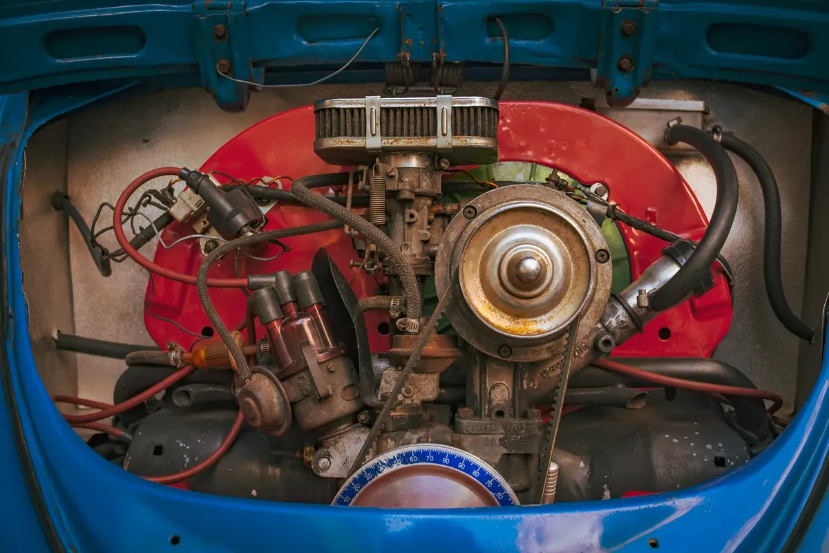 Detailed view of a vintage car engine, showcasing mechanical components and colorful housing.