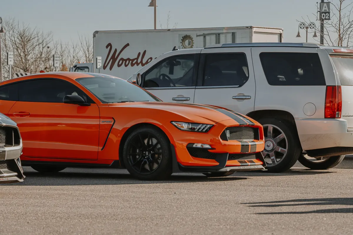 An eye-catching orange Ford Mustang parked in Denver, showcasing its bold design and sports features.